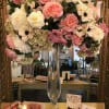 Large pink and white floral arrangement in a tall glass vase