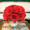 Red roses arranged in a clear glass vase