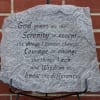 Engraved gray stone plaque with a quote on a brick wall