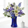 Blue vase holding white and purple flowers