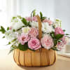 Pink and white flowers arranged in a wooden basket
