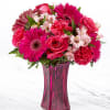 Pink mixed flower bouquet in a tall magenta vase