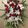 Standing floral spray with red roses, white lilies, and orchids