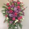Large standing floral spray with pink, purple, and white blooms