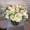 Pastel rose bouquet in a glass vase with white filler flowers