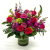 Bouquet of pink roses and magenta flowers in a glass vase
