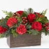 A rustic wood box filled with greens and blooms of the season.
