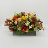 Low centerpiece of orange roses, yellow mums, and mixed flowers in a rustic wooden box.
