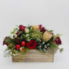 Low red and white flower arrangement with protea and roses in a wooden rectangular box with red ornaments.