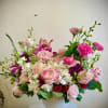 A lush mix of blush and hot pink roses and ranunculus creates