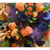 Orange and black floral arrangement with orchids and roses
