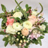 Mixed bouquet of pale roses and white blooms in a glass vase