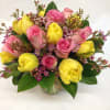 Bouquet of pink roses and yellow tulips in a glass vase
