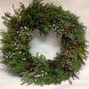 A large evergreen wreath with pinecones and silver accents