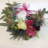 Heart-shaped floral wreath with pink roses and a ribbon bow