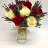 Red and cream roses with purple lavender in a glass jar vase