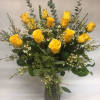 Yellow roses arranged in a clear glass vase with white filler flowers