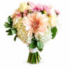 A peach dahlia crowns this hand-tied flower arrangement, opening into layers of