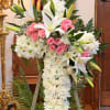 White floral standing cross with pink roses and lilies