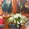 White floral arrangement with lilies and calla lilies on a wooden altar