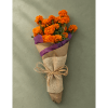 Bouquet of orange marigolds wrapped in brown paper with purple trim