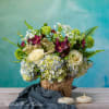 Floral arrangement in a birch bark container with candles in front