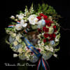 Large funeral wreath with red roses, white orchids, and blue hydrangeas
