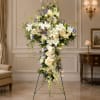 Tall standing floral cross with white and lavender flowers on a metal easel