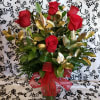 Red roses arranged in a clear glass vase with a red ribbon