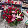 Bouquet of red roses and pink lilies with a red ribbon