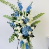 Tall blue and white floral standing arrangement on an easel