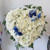 Heart-shaped white floral standing arrangement with blue accents
