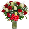 Arrangement of red and white roses with baby's breath in a clear glass vase with a red bow