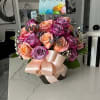 Bouquet of pink, peach, and lavender roses with a birthday card and ribbon