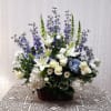 Large basket arrangement with white lilies, roses, hydrangeas, and purple delphinium