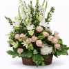 Basket arrangement of pink roses and white lilies with tall white blooms