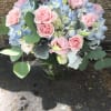 Pink roses and blue hydrangeas in a glass vase