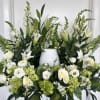 White floral arrangement with lilies, roses, and green hydrangeas in a vase