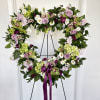 Heart-shaped floral wreath on an easel with a purple ribbon
