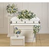 White casket spray with blue and cream flowers on a white casket