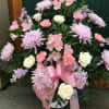 Pink and white floral arrangement with roses, carnations, and lilies in a vase