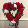 Heart-shaped wreath of red and white carnations on an easel
