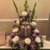 White and purple roses arranged around a silver urn