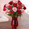 Bouquet of red and pink roses in a red glass vase