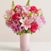 Pink bouquet of roses, lilies, and chrysanthemums in a tall vase