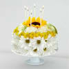 Sunflower and daisy cake with lit candles on a pedestal stand