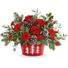 Red roses and carnations in a red container with pinecones
