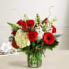 Red roses and gerbera daisies in a glass vase