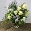 White blooms arranged around seasonal pine and ceder to give you an