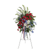 Standing floral spray with red carnations, white lilies, and blue flowers on an easel